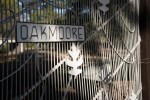 Close-up of a metal gate with "OAKMOORE" sign and leaf motif.