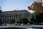A classical building with columns in the background and a stone lion sculpture in the foreground.